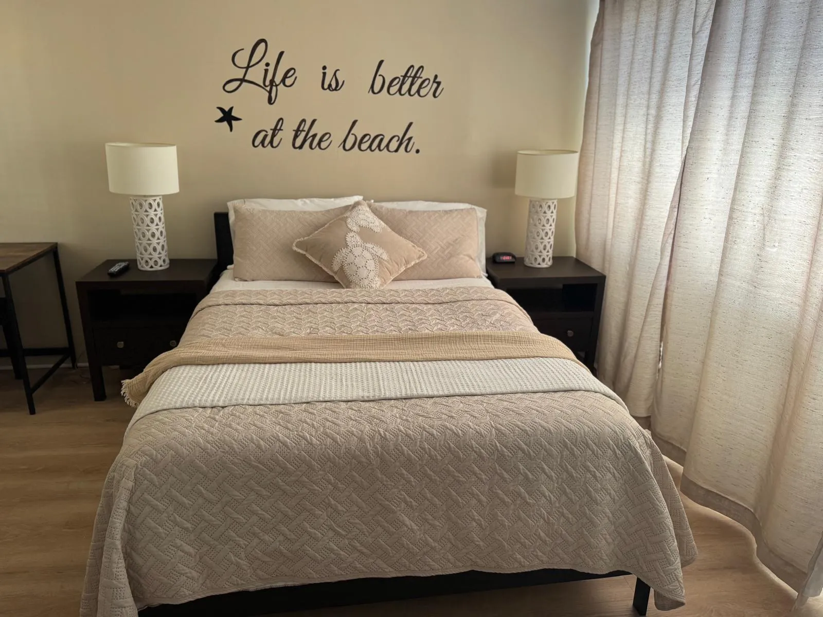 Bedroom with "Life is better at the beach" wall art