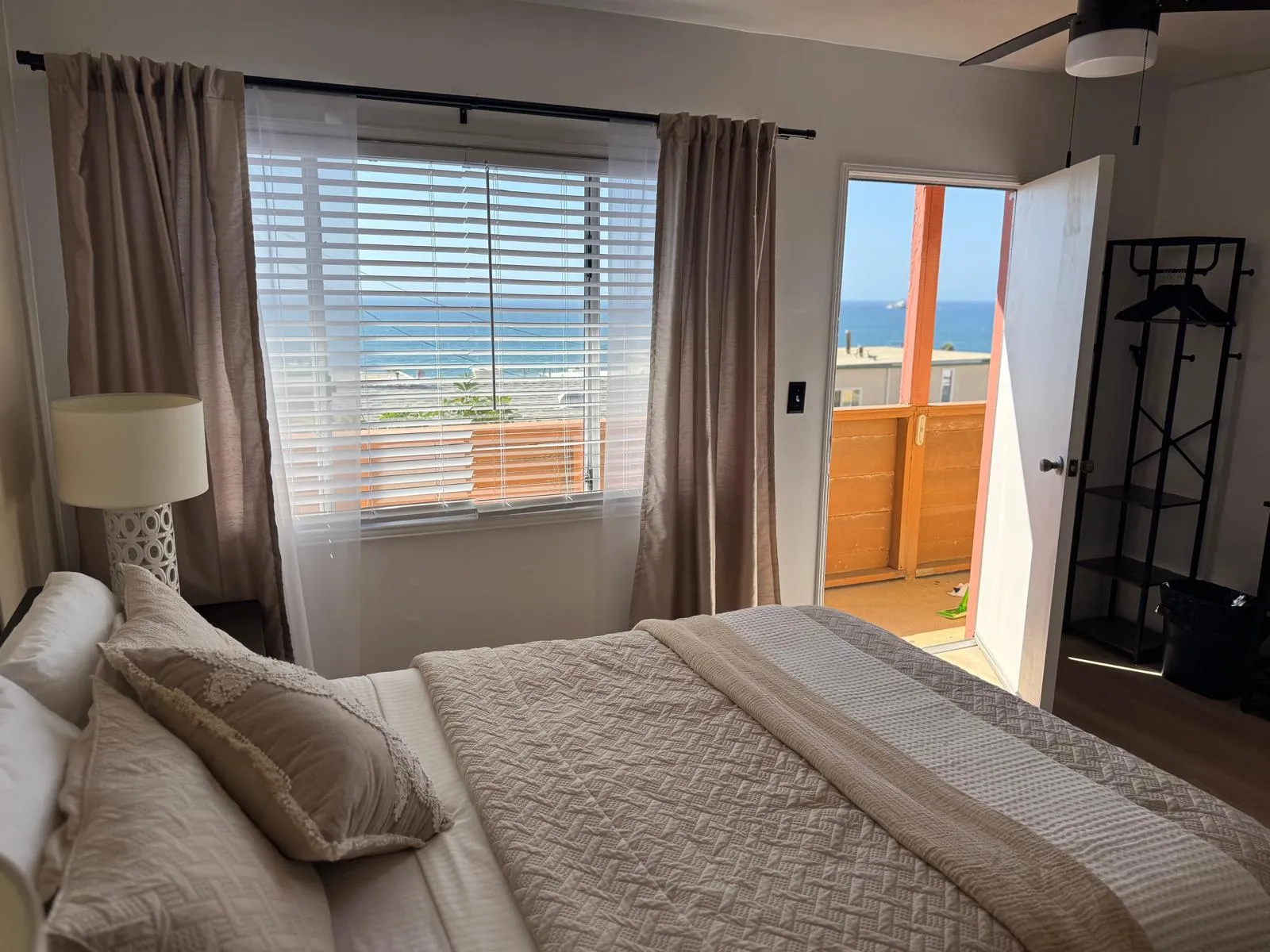 Bedroom with curtains and ocean view through the window